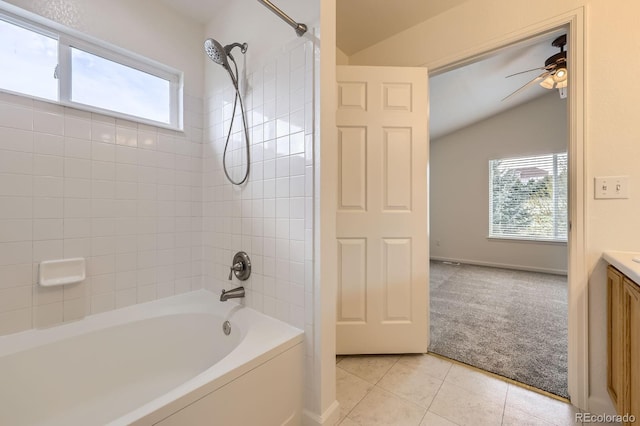 full bathroom featuring plenty of natural light, tile patterned floors, vaulted ceiling, vanity, and shower / washtub combination