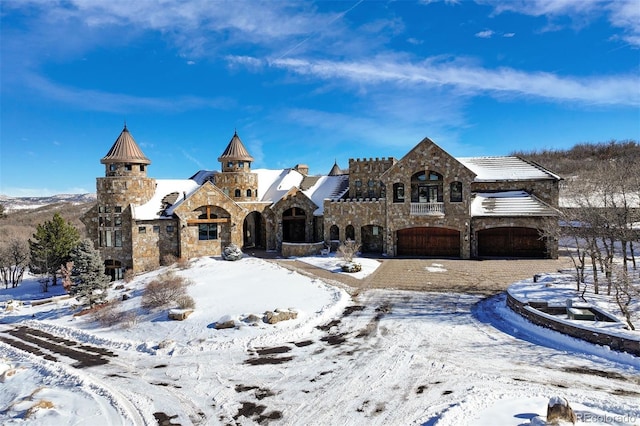 french provincial home with a garage and stone siding