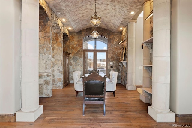 unfurnished dining area with brick ceiling, vaulted ceiling, french doors, hardwood / wood-style flooring, and decorative columns