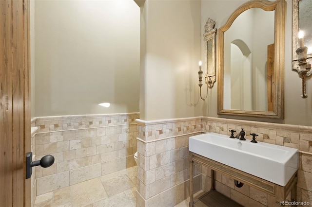 bathroom with a wainscoted wall and tile walls