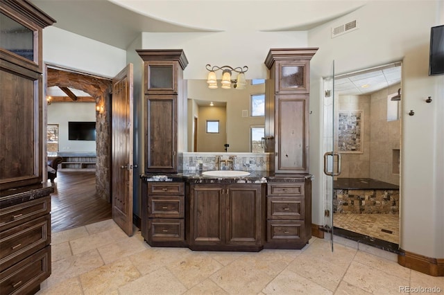 ensuite bathroom with visible vents, ensuite bath, stone tile flooring, vanity, and a shower stall