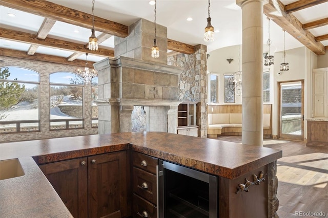 kitchen featuring pendant lighting, dark brown cabinetry, wine cooler, hardwood / wood-style flooring, and beam ceiling