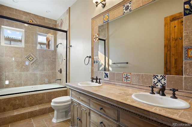 full bathroom featuring tasteful backsplash, toilet, shower / bath combination with glass door, and vanity