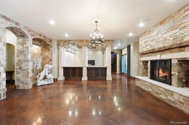 unfurnished living room with a fireplace and ornate columns