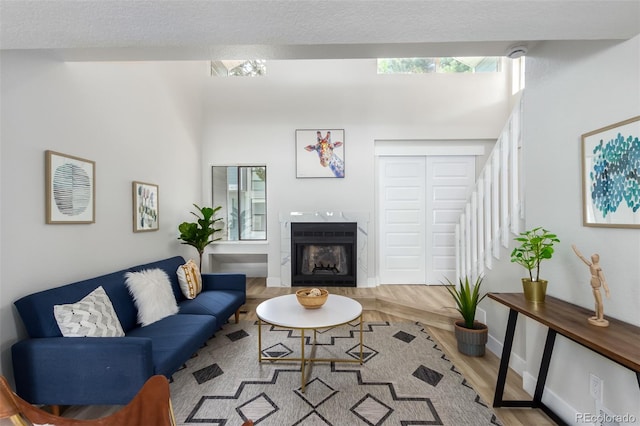 living room featuring light wood-type flooring, a fireplace, and a textured ceiling