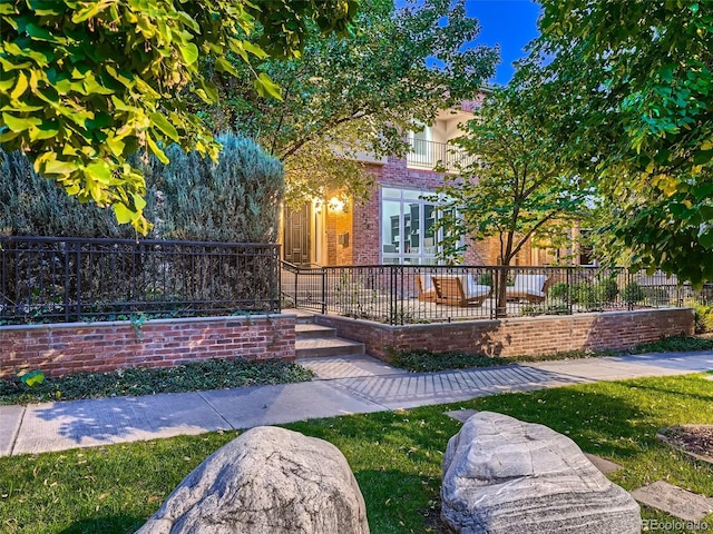 view of front of home featuring fence private yard and brick siding