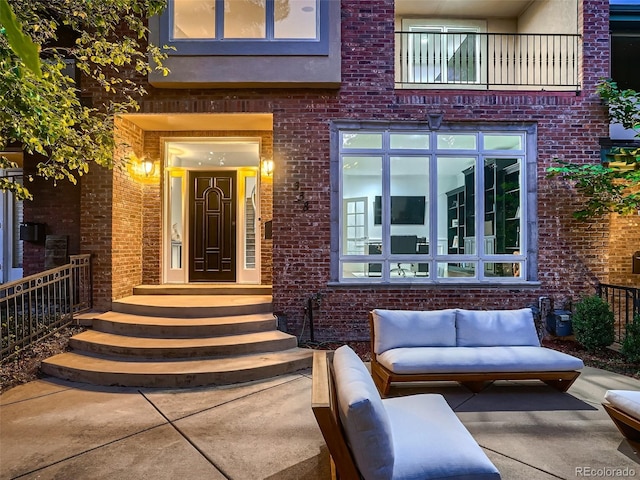 entrance to property featuring brick siding and an outdoor hangout area