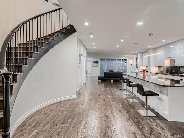 foyer entrance featuring stairs, recessed lighting, baseboards, and wood finished floors