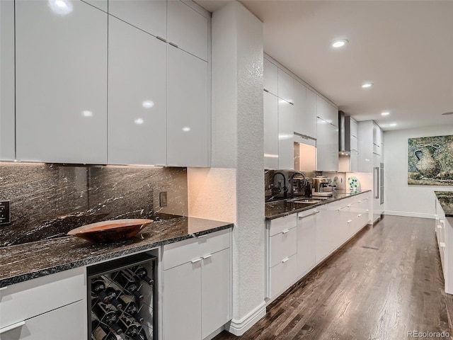 kitchen featuring a sink, modern cabinets, backsplash, and beverage cooler