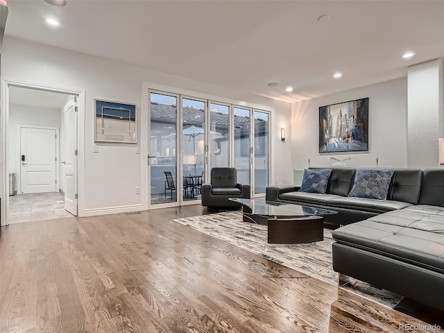 living room featuring baseboards, recessed lighting, and wood finished floors