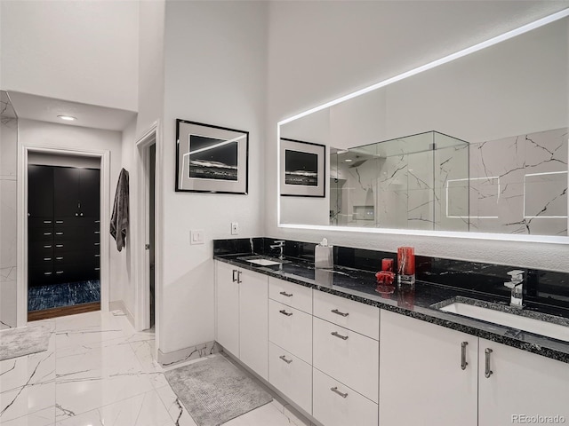 bathroom with a sink, a marble finish shower, double vanity, and marble finish floor