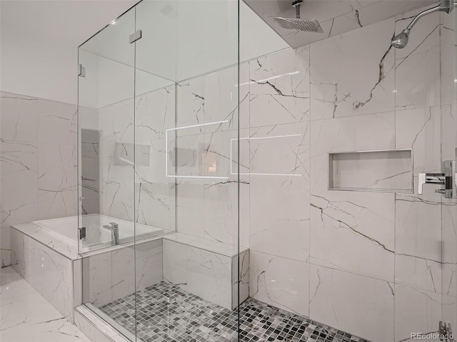 bathroom with marble finish floor, a marble finish shower, and tile walls
