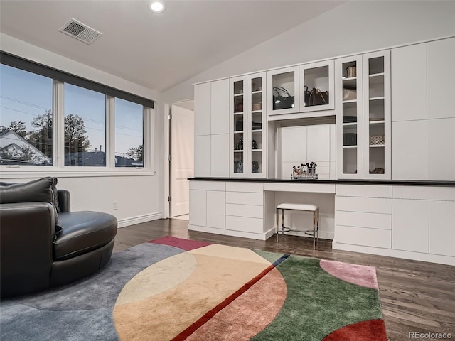 living room featuring dark wood-style flooring, built in desk, recessed lighting, lofted ceiling, and visible vents