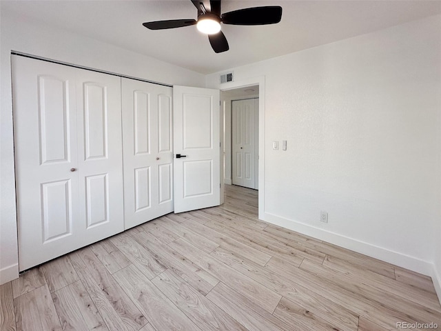 unfurnished bedroom featuring ceiling fan, light wood-type flooring, and a closet