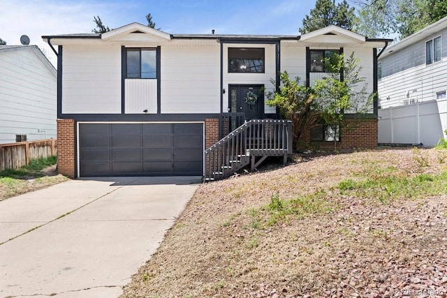 527 W Columbia St, Colorado Springs, CO 80907 - raised ranch with brick siding, concrete driveway, and a garage