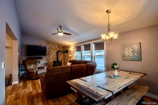472 Ryan Gulch Rd, Silverthorne, CO 80498 - dining space with a wood stove, vaulted ceiling, a chandelier, a ceiling fan, and wood finished floors