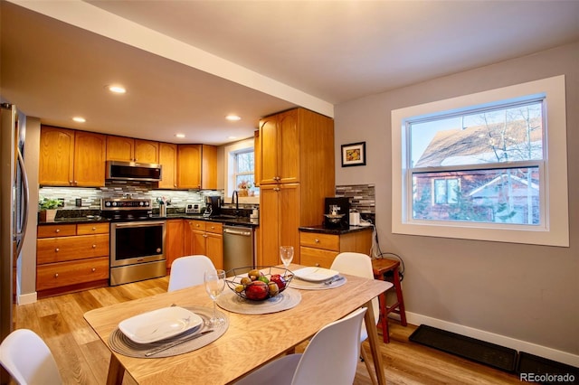 472 Ryan Gulch Rd, Silverthorne, CO 80498 - kitchen featuring appliances with stainless steel finishes, light wood-style floors, decorative backsplash, dark countertops, and recessed lighting