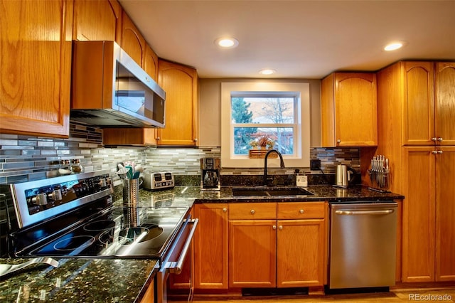 472 Ryan Gulch Rd, Silverthorne, CO 80498 - kitchen featuring stainless steel appliances, a sink, tasteful backsplash, dark stone counters, and brown cabinets