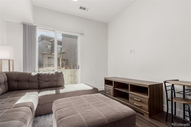 living room featuring dark wood-style floors, visible vents, and baseboards