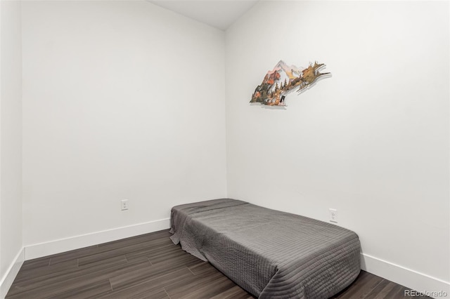 bedroom with baseboards and wood finished floors