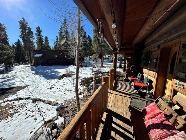 view of snow covered back of property