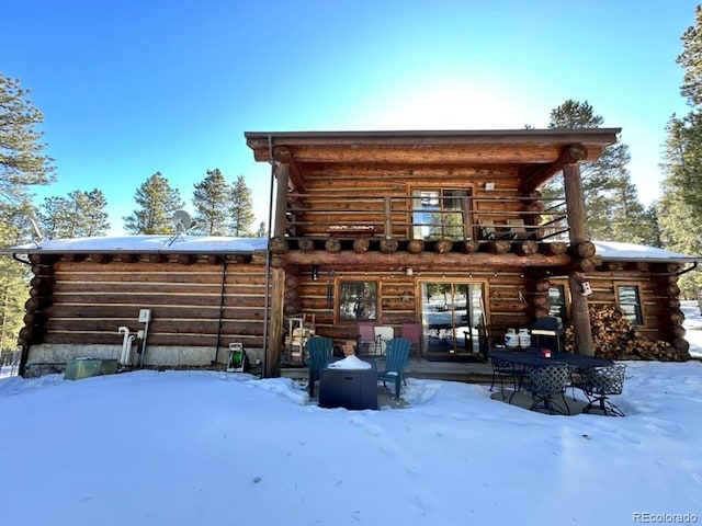 snow covered property with an outdoor fire pit