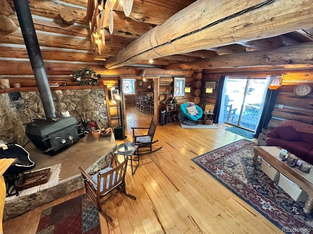 interior space featuring a wood stove, hardwood / wood-style floors, and rustic walls