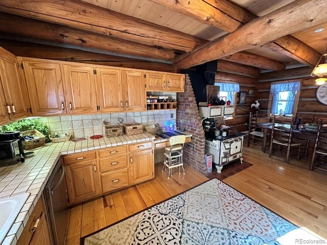 kitchen featuring beamed ceiling, tile counters, light hardwood / wood-style floors, and backsplash