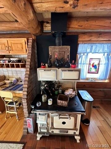 bar with dark hardwood / wood-style flooring, a wood stove, wood ceiling, and beam ceiling