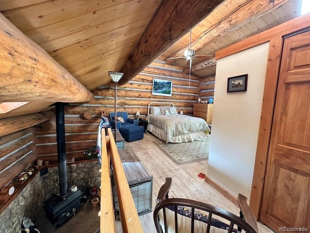 bedroom featuring vaulted ceiling with beams, wooden ceiling, rustic walls, and a wood stove