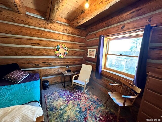 living area featuring beam ceiling, wood ceiling, and log walls