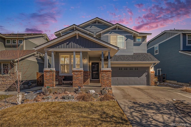 craftsman-style home with brick siding, a porch, a garage, driveway, and a front lawn