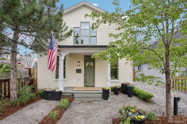 view of front facade featuring a porch and fence