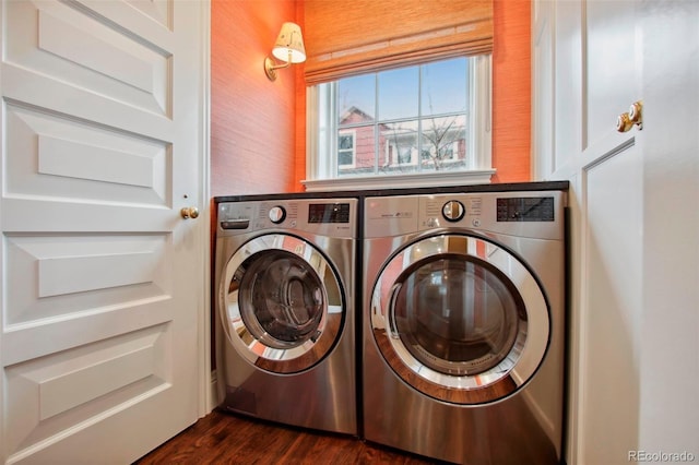 clothes washing area featuring washing machine and dryer, laundry area, and dark wood finished floors