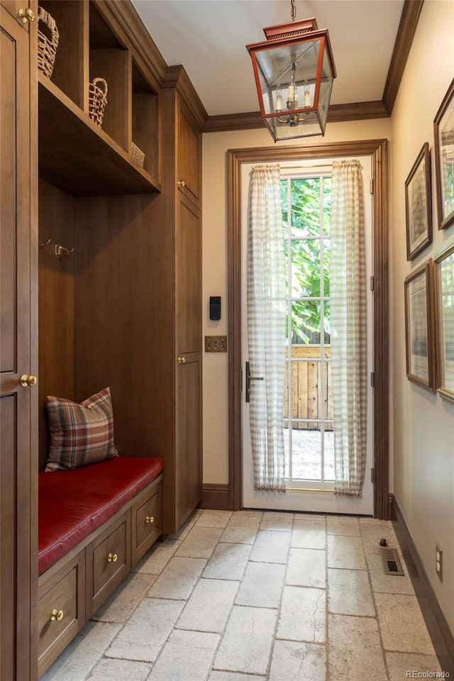 mudroom featuring baseboards, crown molding, visible vents, and stone tile flooring