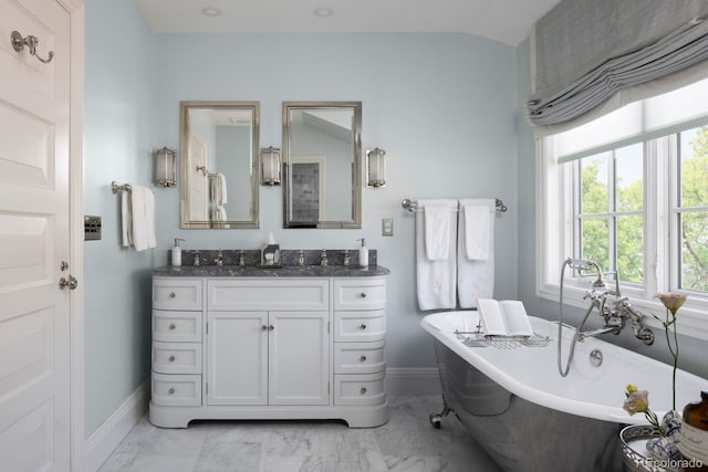 bathroom featuring vanity, baseboards, marble finish floor, and a freestanding tub
