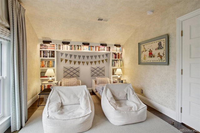 bedroom featuring vaulted ceiling, baseboards, visible vents, and wood finished floors