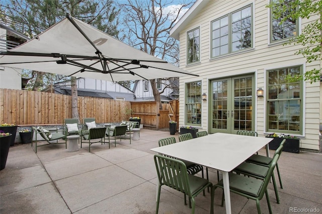 view of patio / terrace with fence, outdoor dining space, and french doors