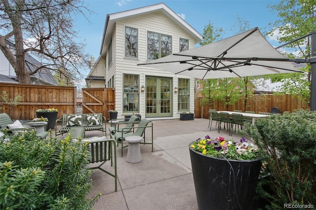 view of patio featuring french doors, outdoor lounge area, a gate, and fence