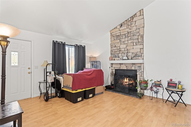 living room featuring hardwood / wood-style flooring, lofted ceiling, and a fireplace