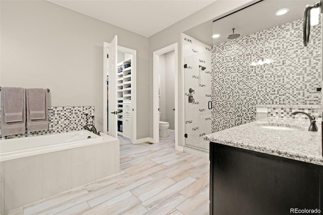 23696 E Del Norte Pl, Aurora, CO 80016 - bathroom with a stall shower, vanity, toilet, a garden tub, and baseboards