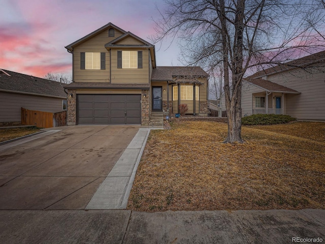 view of front of home featuring fence, an attached garage, stone siding, driveway, and a shingled roof