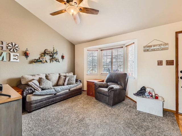carpeted living area with baseboards, lofted ceiling, and a ceiling fan