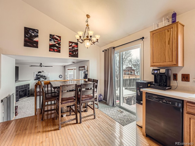 dining room with vaulted ceiling, a fireplace, a healthy amount of sunlight, and light wood-style floors