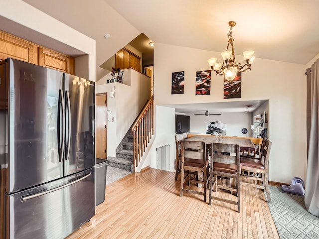 dining room with baseboards, stairway, light wood-style flooring, and ceiling fan with notable chandelier