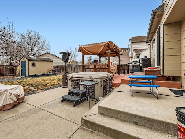 view of patio featuring an outdoor structure, a wooden deck, a fenced backyard, and a shed