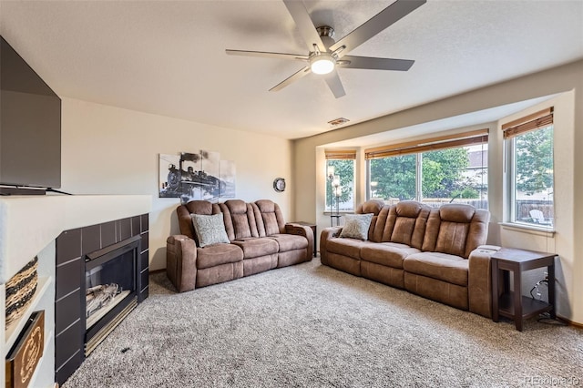 11395 E 116th Dr, Commerce City, CO 80640 - carpeted living room featuring healthy amount of natural light, ceiling fan, and a fireplace