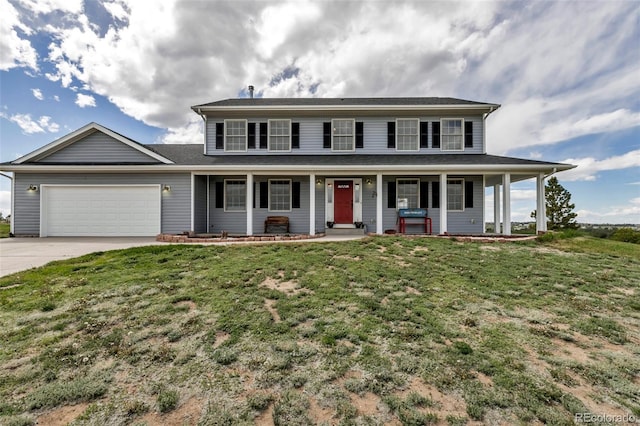 colonial home featuring a garage, concrete driveway, covered porch, and a front yard