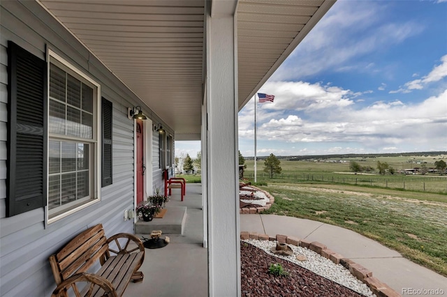 view of patio with covered porch and a rural view