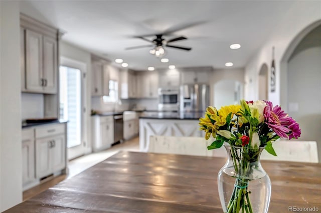 dining room with arched walkways, a ceiling fan, recessed lighting, and wood finished floors